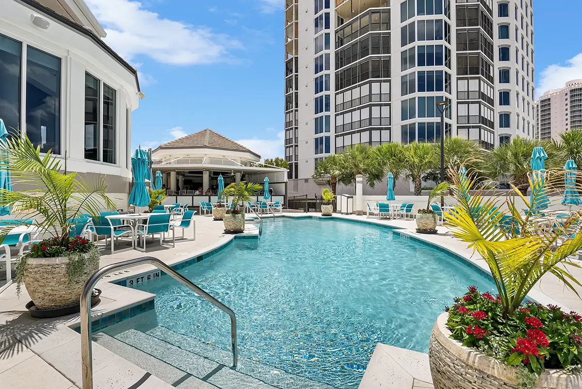 Heated pool terrace at the Bay Colony Beach Club with the Chickee Bar pavilion and Bay Colony towers behind, Naples, Florida