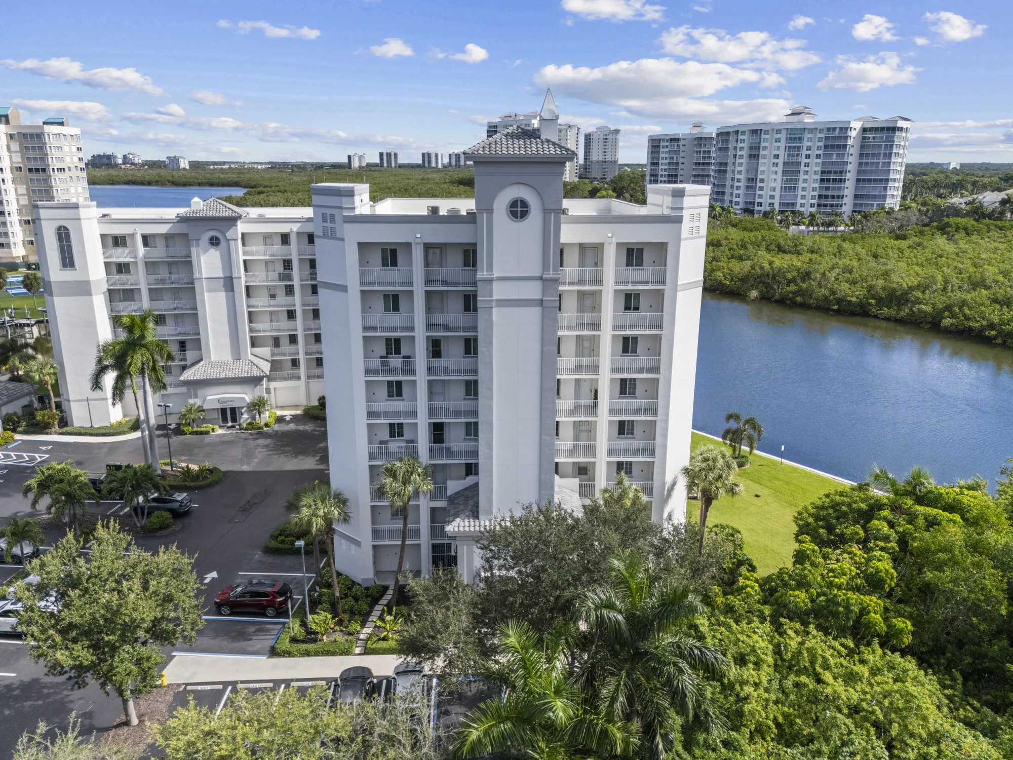 Aerial of Baypoint at 35 Bluebill Avenue, the seven-story second building of Baypoint, beside the Vanderbilt Channel, with the Bluebill Avenue towers beyond, Vanderbilt Beach, Naples, Florida