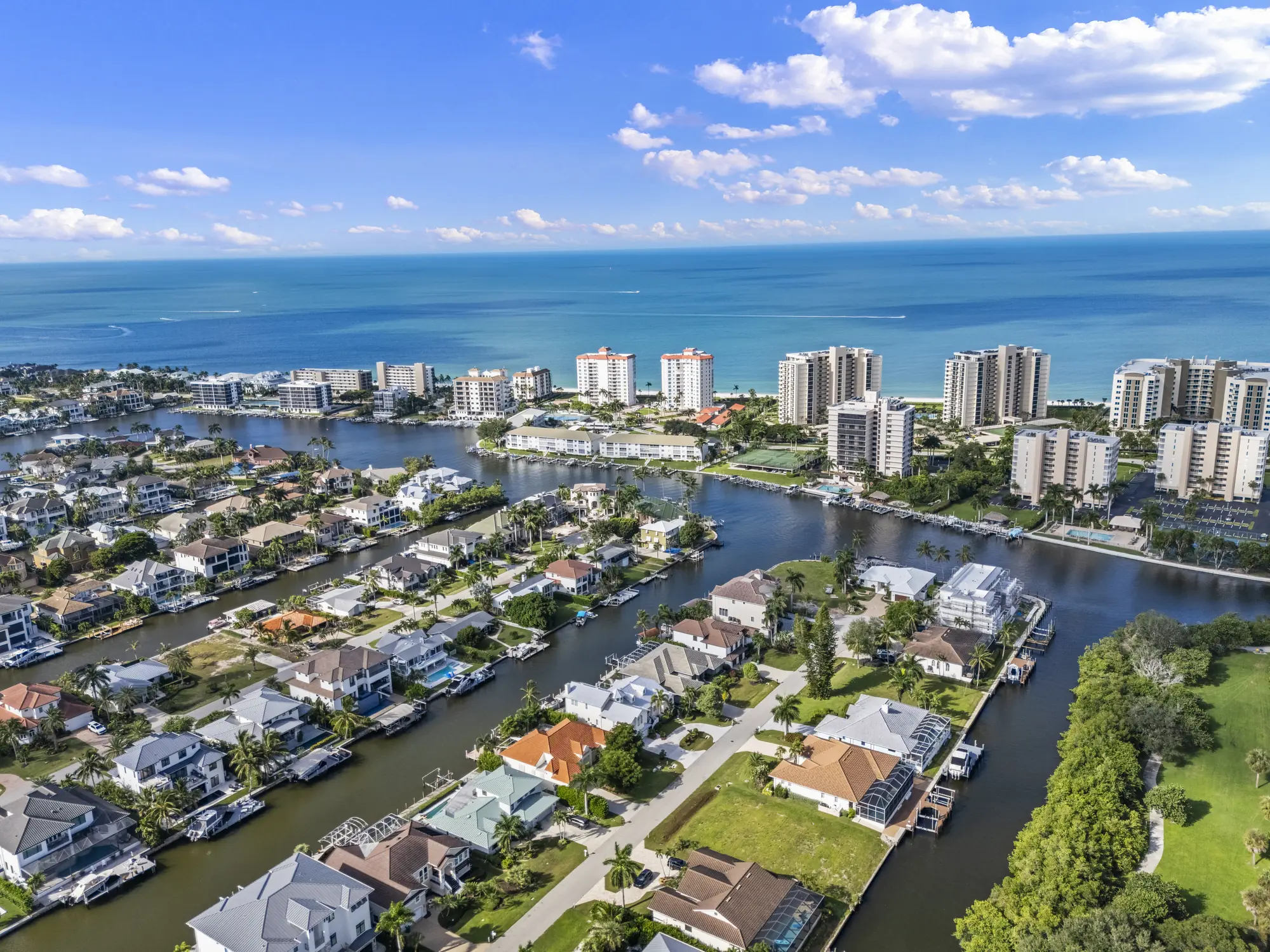 Aerial of Conners canal-front homes and private docks at Vanderbilt Beach, with Vanderbilt Lagoon and the Gulf beyond