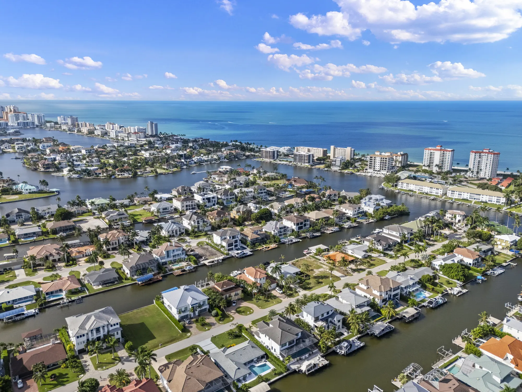 Aerial of Conners canal streets at Vanderbilt Beach, where original homes and newly built elevated homes share the same canals
