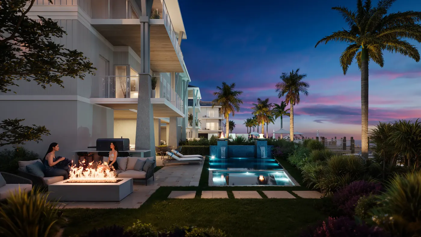 Ground-floor Garden Retreat at Harbour House Naples at dusk, with a private pool, fire pit and outdoor kitchen beside the bay