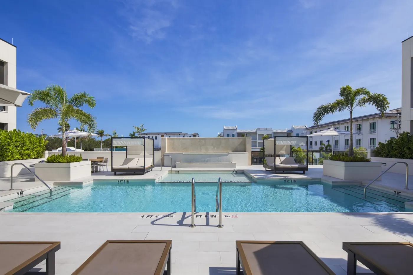 Resort-style pool with sun shelf and cabanas on the amenity deck at Stella Naples, Olde Naples, Florida