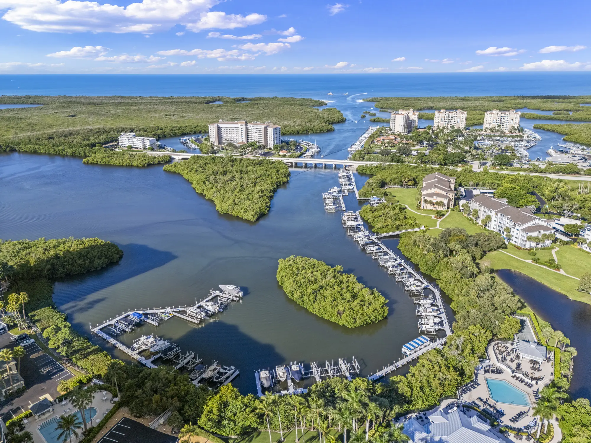 Aerial of the Wiggins Bay docks in North Naples, with the bay running out toward Wiggins Pass and the Gulf